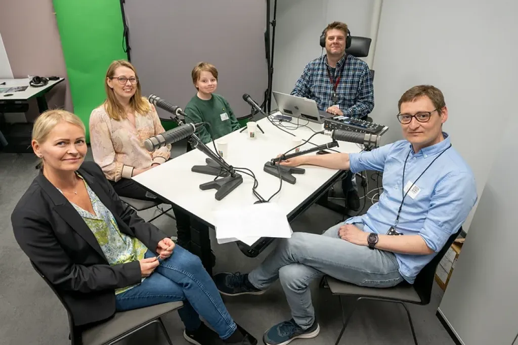 Deltagerne i podcasten sitter samlet rundt bordet i samband med innspilling. 