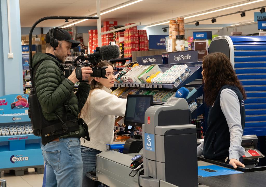 NRK intervjuer kjøpmann Mona Lie på Rema 1000 bak kassa.
