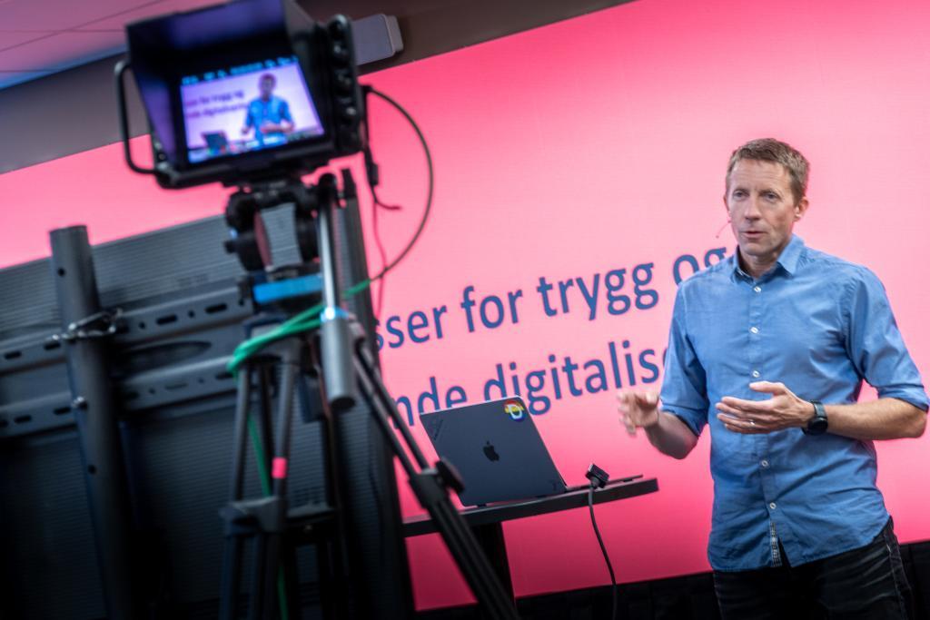Person som står foran kamerat og snakker. 